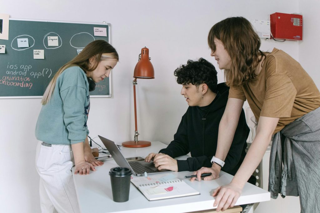 Eine Gruppe junger Entwickler führt in einem modernen Büroumfeld ein Brainstorming zu Ideen für ein Technologie-Startup durch.